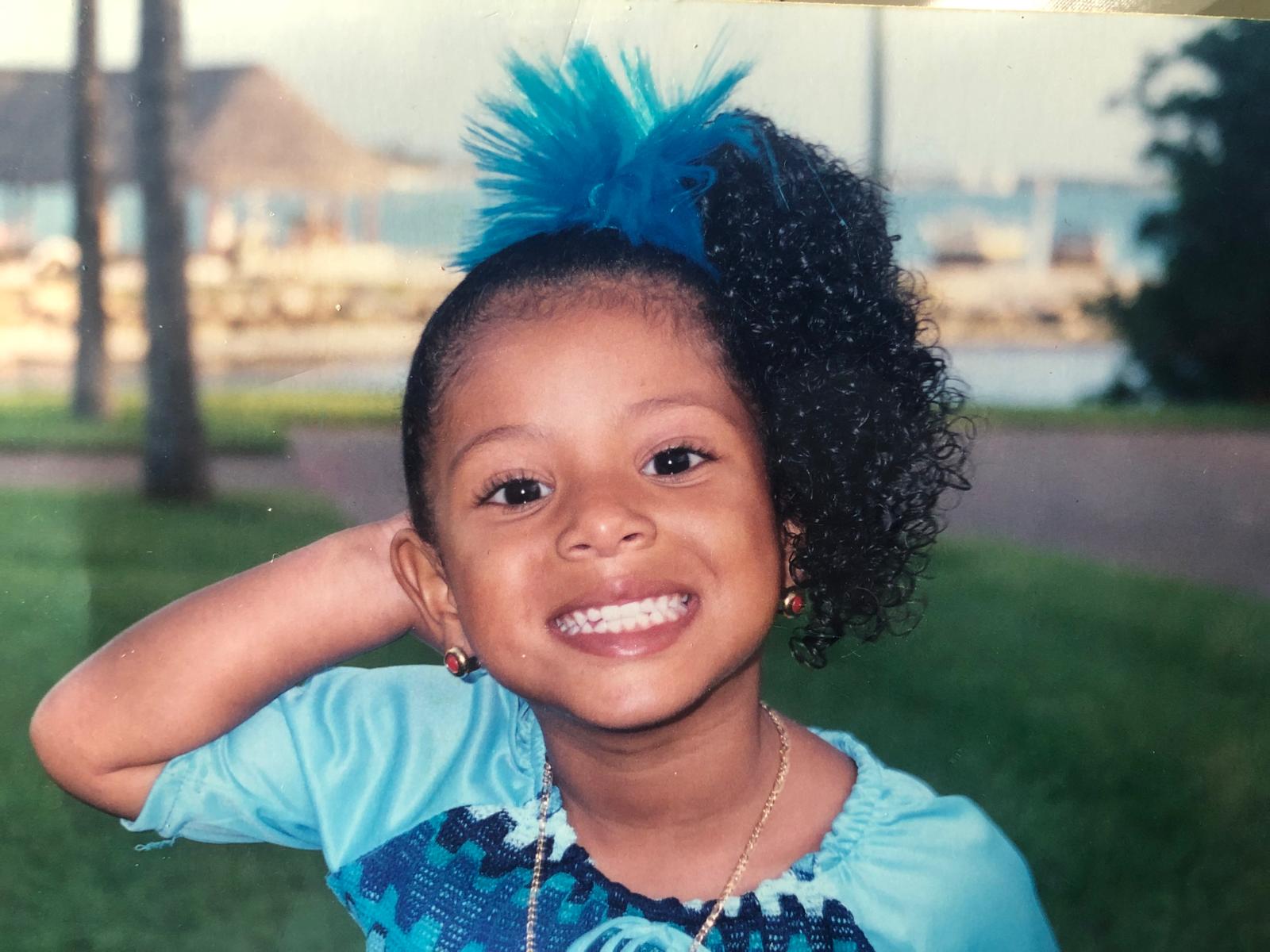 Naomi as a child, outdoors in Aruba.