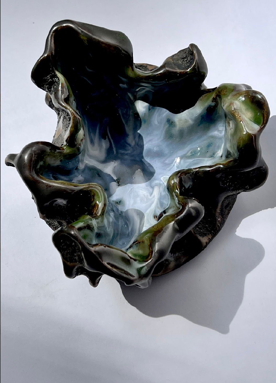 Lava collection bowl by Naomi Tromp with black and blue magma-like glaze.